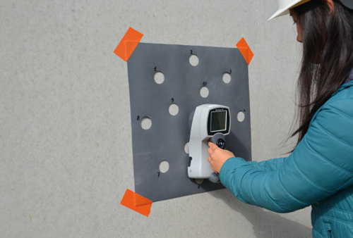 Bij een betonnen wand worden de tintverschillen gecontroleerd op een objectieve manier met behulp van een colorimeter