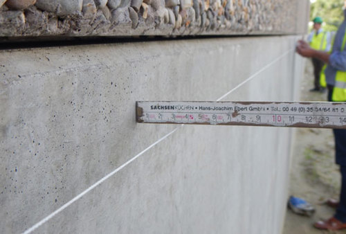 La courbure d’un élément en béton se mesure au moyen d’une corde tendue et d’un mètre pliant.