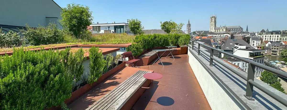 Klimaatdak met dichte beplanting, zitplekken en een terras met uitzicht over de stad.